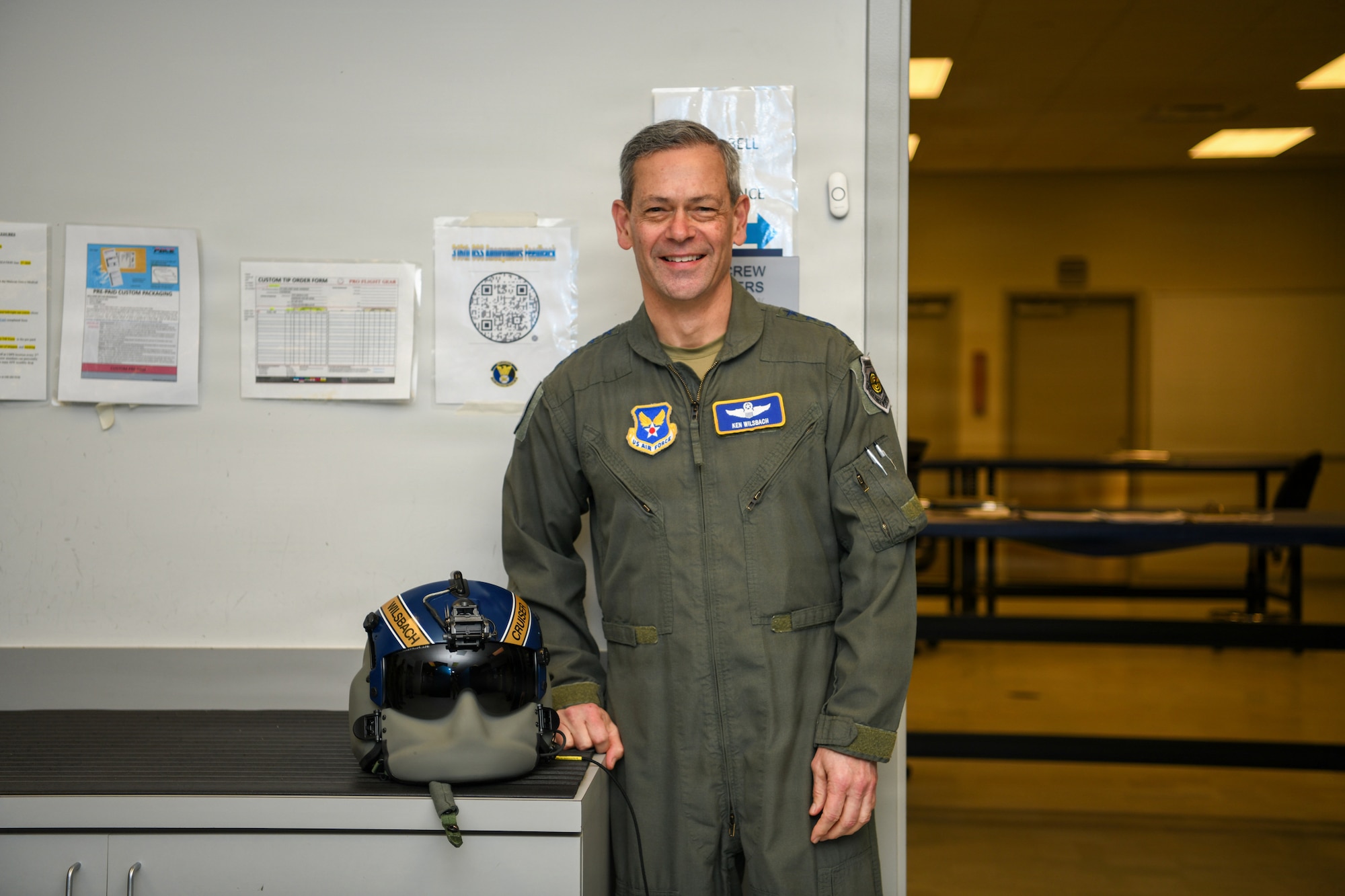 Air Force Chief of Staff Gen. Ken Wilsbach stands with a custom helmet from the 1st Helicopter Squadron.