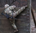 Illinois Army National Guard Spc. Dayanara Islas, assigned to the Springfield-based 233rd Military Police Co. climbs a wall during the 233rd’s 