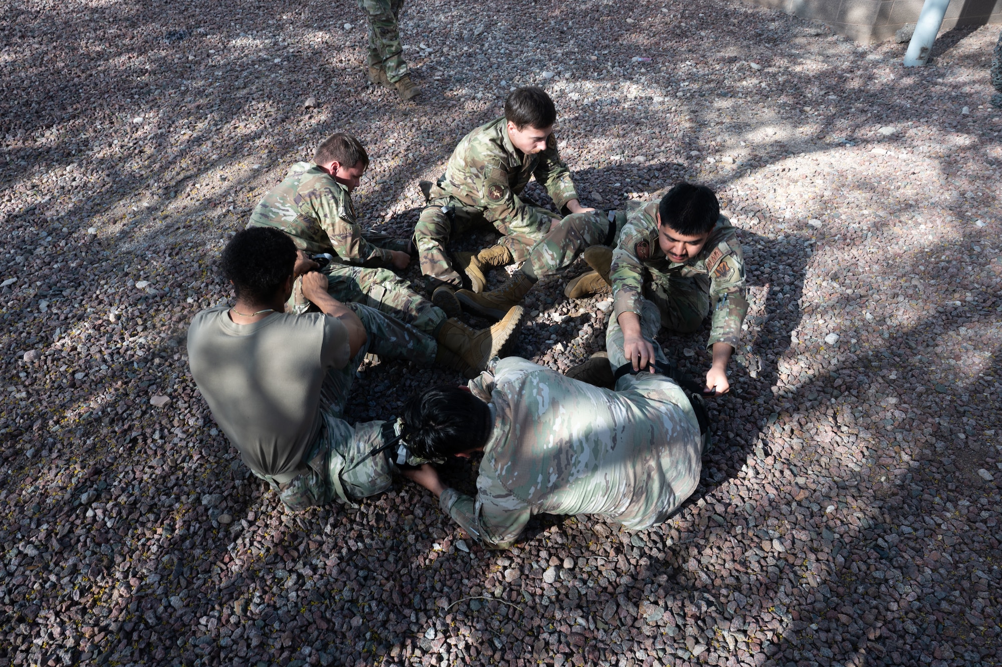 U.S. Air Force Airmen participating in a Tactical Combat Casualty Care course apply tourniquets to one another during a Mission Ready Airmen course at Davis-Monthan Air Force Base, Arizona, March 31, 2026. MRA participants receive hands-on briefings on operational environments, chemical preparedness and tactical combat casualty care to ensure they are ready to deploy at a moment’s notice. (U.S. Air Force photo by Airman 1st Class Jaden Kidd)