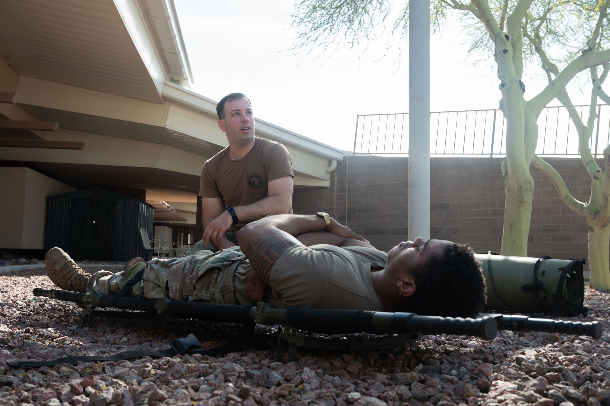 U.S. Air Force Staff Sgt. Andrew Mack, 612th Air Operations Center battle management operator and Mission Ready Airman instructor, secures Senior Airman Jonathan Turk, 355th Contracting Squadron contracting specialist, to a stretcher at Davis-Monthan Air Force Base, Arizona, March 31, 2026. The training provided valuable insight to the readiness of Airmen and their future deployments. (U.S. Air Force photo by Airman 1st Class Jaden Kidd)