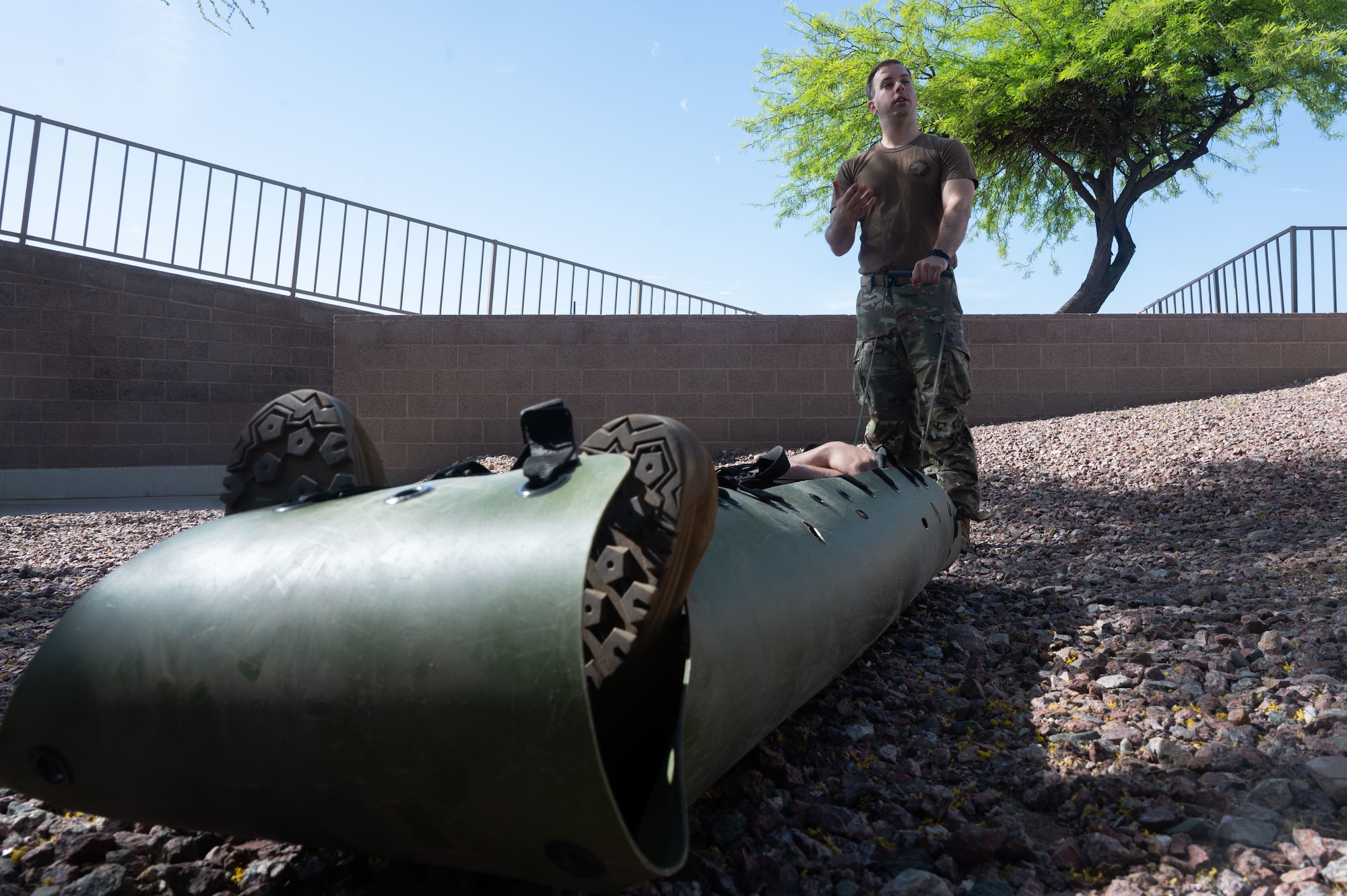 U.S. Air Force Staff Sgt. Andrew Mack, 612th Air Operations Center battle management operator and Mission Ready Airman instructor, secures Airman 1st Class Tyler Trimino, 355th Logistics Readiness Squadron ground transportation specialist, to a Sked stretcher at Davis-Monthan Air Force Base, Arizona, March 31, 2026. Through the MRA program, DM continues to equip Airmen with the knowledge and skills needed to remain ready for any operational challenge. (U.S. Air Force photo by Airman 1st Class Jaden Kidd)