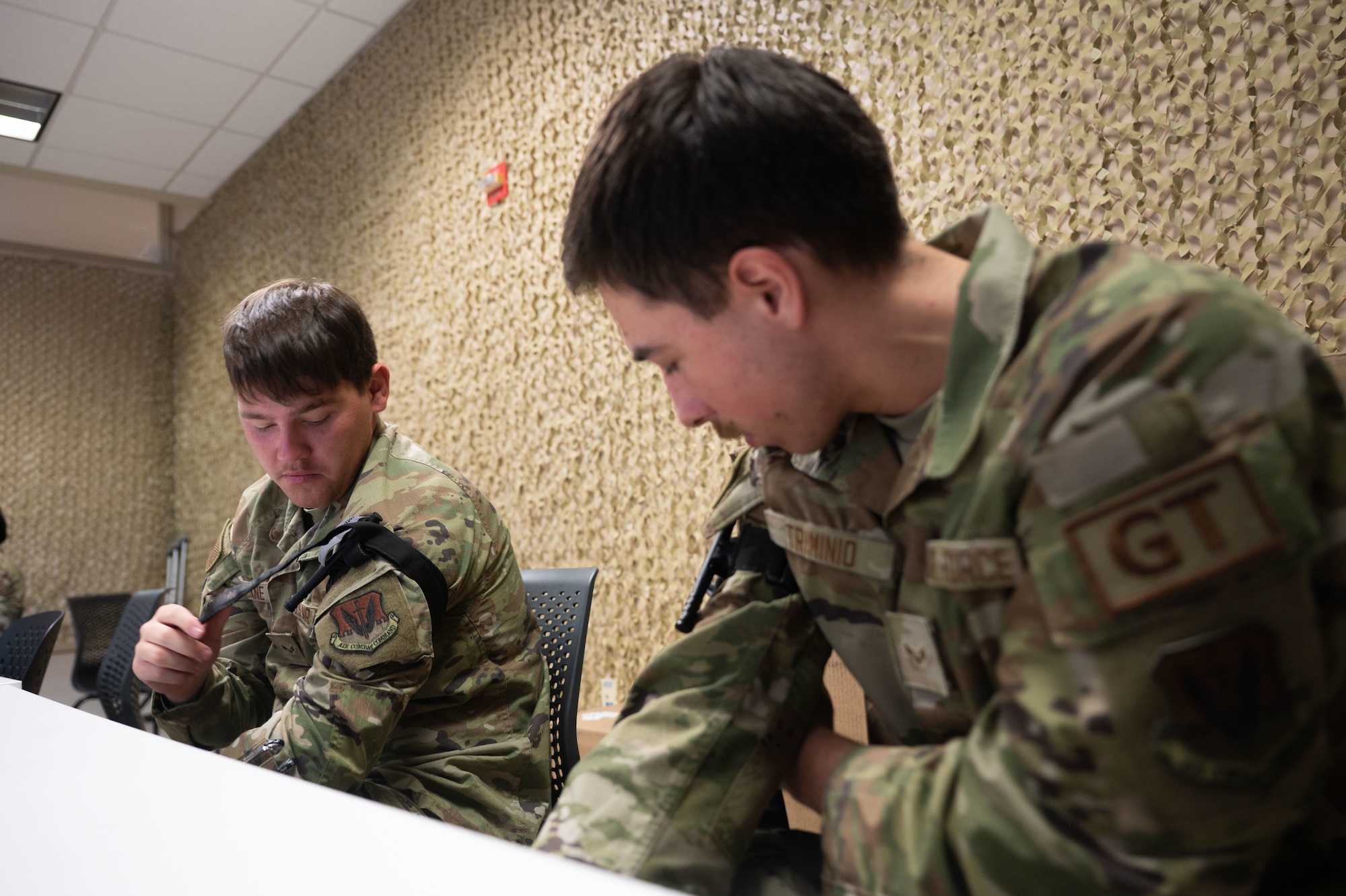 U.S. Air Force Airman 1st Class Keaton Bane, 355th Logistics Readiness Squadron ground transportation specialist, left, and Airman 1st Class Tyler Trimino, 355th Logistics Readiness Squadron ground transportation specialist, right, apply tourniquets to themselves during a Tactical Combat Casualty Care course at Davis-Monthan Air Force Base, Arizona, March 31, 2026. The Mission Ready Airmen program helps bridge the gap between initial training and the realities of the operational Air Force. (U.S. Air Force photo by Airman 1st Class Jaden Kidd)