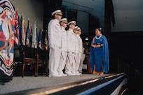 JOINT BASE PEARL HARBOR-HICKAM, Hawaii (March 12, 2026) - Kumu Pualeilani Kamahoahoa, right, professional educator of Hawaiian culture, delivers blessings to the official party during the change of command ceremony for Virginia-class fast-attack submarine USS Hawaii (SSN 776), at Sharkey Theater on Joint Base Pearl Harbor-Hickam, Hawaii, March 12, 2026. Hawaii is assigned to Submarine Squadron 1 and is capable of supporting various missions, including anti-submarine warfare, anti-surface ship warfare, strike warfare, special operations forces support, and intelligence, surveillance, and reconnaissance. (U.S. Navy photo by Mass Communication Specialist 2nd Class Nicholas Russell)
