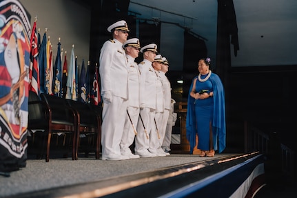 JOINT BASE PEARL HARBOR-HICKAM, Hawaii (March 12, 2026) - Kumu Pualeilani Kamahoahoa, right, professional educator of Hawaiian culture, delivers blessings to the official party during the change of command ceremony for Virginia-class fast-attack submarine USS Hawaii (SSN 776), at Sharkey Theater on Joint Base Pearl Harbor-Hickam, Hawaii, March 12, 2026. Hawaii is assigned to Submarine Squadron 1 and is capable of supporting various missions, including anti-submarine warfare, anti-surface ship warfare, strike warfare, special operations forces support, and intelligence, surveillance, and reconnaissance. (U.S. Navy photo by Mass Communication Specialist 2nd Class Nicholas Russell)