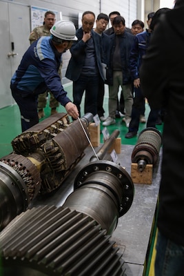 U.S. Army Chief Warrant Officer 5 Robert Henrikson, 2nd Infantry Division (2ID), Chief Warrant Officer 2 Eric Duddy, 194th Division Sustainment Battalion, and Maj. James Buensuceso, 2ID, are guided by South Korea Navy service members through a navy shipyard for close interaction with 3D printers used for their equipment, Changwon, South Korea, March 25, 2026.