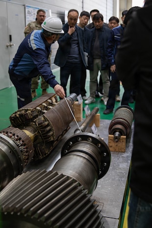 U.S. Army Chief Warrant Officer 5 Robert Henrikson, 2nd Infantry Division (2ID), Chief Warrant Officer 2 Eric Duddy, 194th Division Sustainment Battalion, and Maj. James Buensuceso, 2ID, are guided by South Korea Navy service members through a navy shipyard for close interaction with 3D printers used for their equipment, Changwon, South Korea, March 25, 2026.