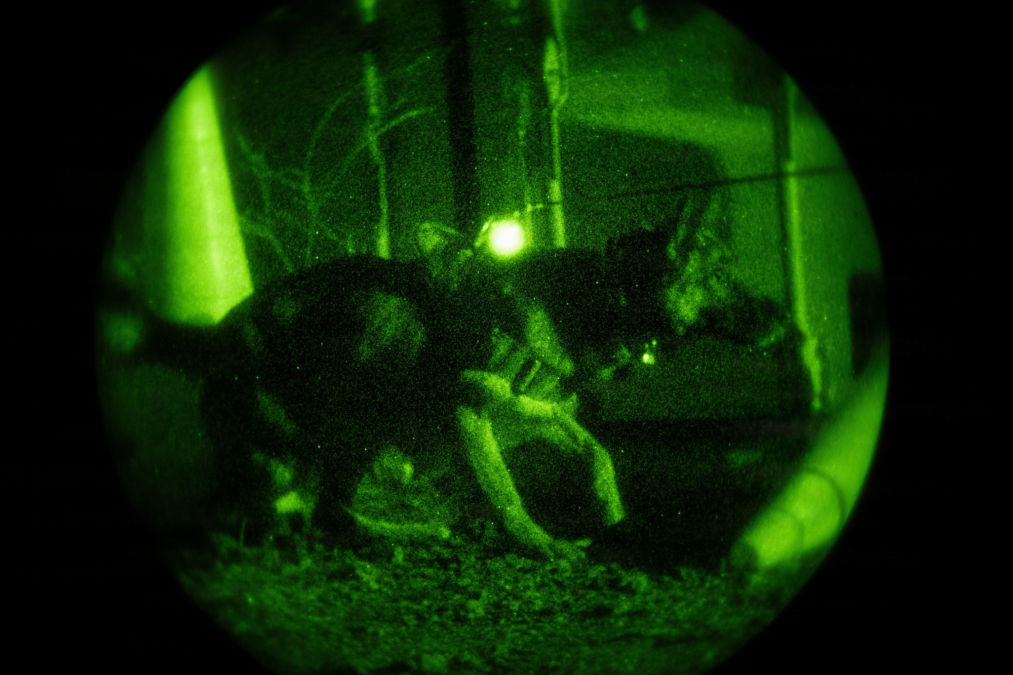 Airmen working with K9 military Working Dogs in night vision