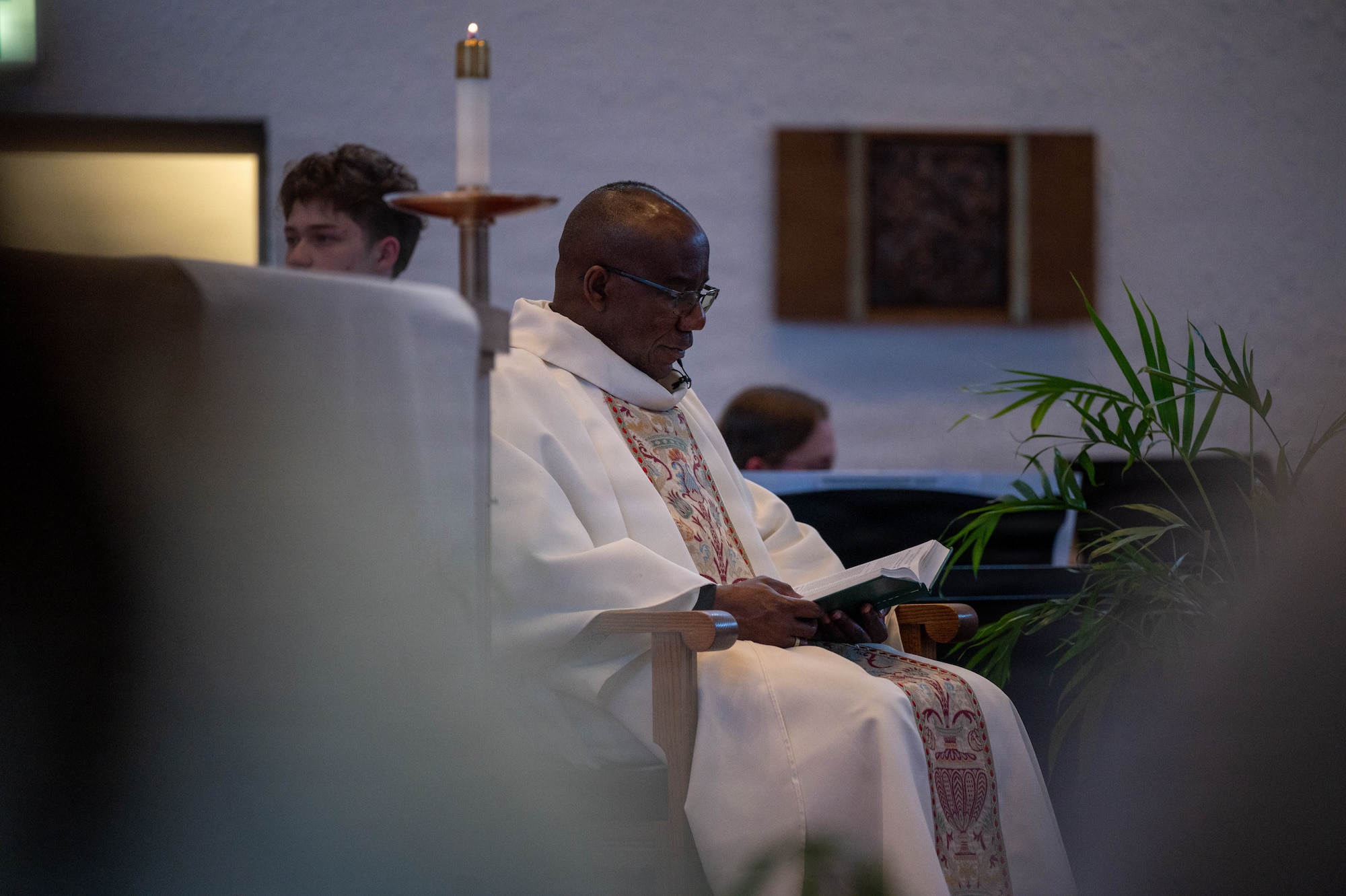 U.S. Air Force Maj. Nelson O. Ogwuegbu, 86th Airlift Wing senior priest, reads scripture during a Holy Thursday mass at the Northside Chapel at Ramstein Air Base, Germany, April 2, 2026.