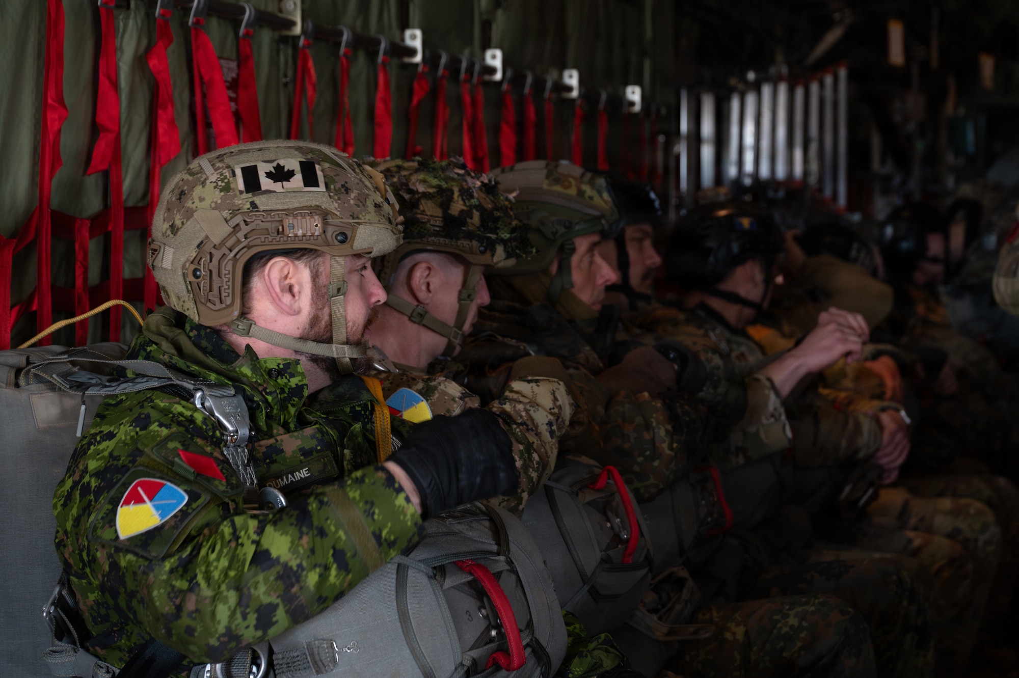 men prepare to jump out of a plane with a parachute
