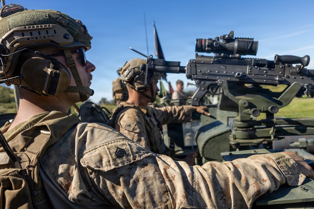 U.S. Marine Corps Sgt. Alexander Taylor, light armored vehicle gunner, left and Lance Cpl. Alex Schmidt, a light armored reconnaissance Marine, right, both with 2d Light Armored Reconnaissance Battalion, 2d Marine Division, await the start of the light armored vehicle live-fire range event during the 2026 Bushmaster Competition, Camp Pendleton, California, March 27, 2026. This year, hosted by 4th Light Armored Reconnaissance, 4th Marine Division, the friendly competition gathers Light Armored Vehicle crews from across the U.S. Marine Corps, Australia and New Zealand to test their tactical and technical skills. (U.S. Marine Corps photo by Sgt. Aaron TorresLemus)