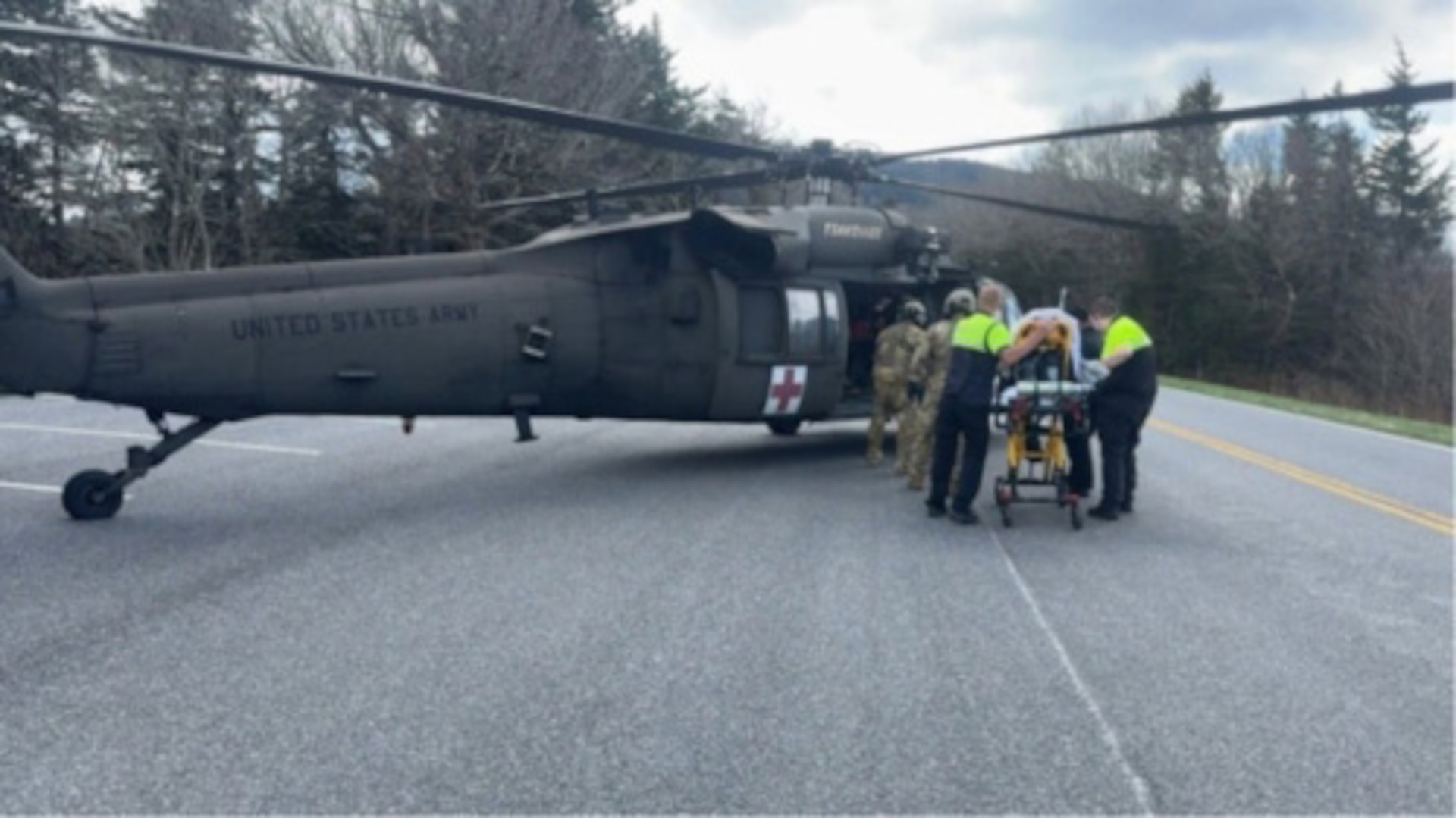 Tennessee Guardsmen and local Emergency Medical Services transfer a park visitor experiencing cardiac arrest into a Tennessee Army National Guard UH-60 Black Hawk along Kuwohi Road in the Great Smoky Mountains National Park, April 1, 2026.
