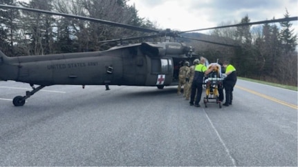 Tennessee Guardsmen and local Emergency Medical Services transfer a park visitor experiencing cardiac arrest into a Tennessee Army National Guard UH-60 Black Hawk along Kuwohi Road in the Great Smoky Mountains National Park, April 1, 2026.