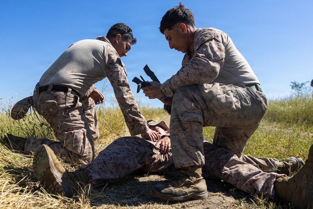 U.S. Marine Corps Sgt. Jaiden Cano, left, Sgt. Ethan Corbin, middle and Lance Cpl. Samuel Martinez, right, with 1st Light Armored Reconnaissance, 1st Marine Division, participate in a tactical combat casualty care event during the 2026 Bushmaster Competition, Camp Pendleton, California, March 25, 2026. This year, hosted by 4th Light Armored Reconnaissance, 4th Marine Division, the friendly competition gathers Light Armored Vehicle crews from across the U.S. Marine Corps, Australia and New Zealand to test their tactical and technical skills. (U.S. Marine Corps photo by Sgt. Aaron TorresLemus)