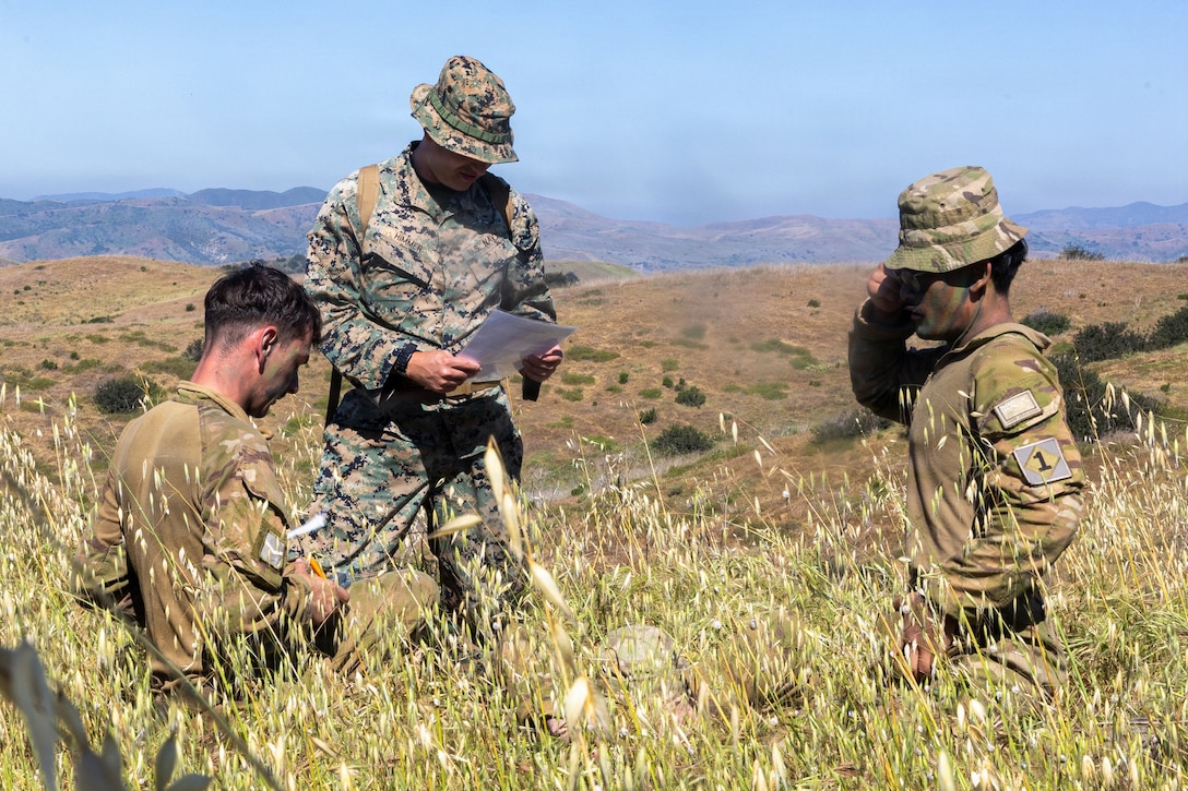 U.S. Navy Hospital Corpsman 3rd Class Tyler Himmer, center, with 2d Light Armored Reconnaissance, 2d Marine Division, finishes his evaluation on soldiers with 1st Battalion, Royal New Zealand Infantry Regiment, for a tactical combat casualty care event during the 2026 Bushmaster Competition, Camp Pendleton, California, March 25, 2026. This year, hosted by 4th Light Armored Reconnaissance, 4th Marine Division, the friendly competition gathers Light Armored Vehicle crews from across the U.S. Marine Corps, Australia and New Zealand to test their tactical and technical skills. (U.S. Marine Corps photo by Sgt. Aaron TorresLemus)