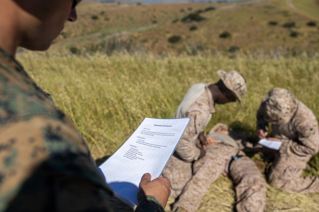 U.S. Navy Hospital Corpsman 3rd Class Micah Nordmoe, left, with 3d Light Armored Reconnaissance, 1st Marine Division, evaluates Marines with 4th Light Armored Reconnaissance, 4th Marine Division, for a tactical combat casualty care event during the 2026 Bushmaster Competition, Camp Pendleton, California, March 25, 2026. This year, hosted by 4th Light Armored Reconnaissance, 4th Marine Division, the friendly competition gathers Light Armored Vehicle crews from across the U.S. Marine Corps, Australia and New Zealand to test their tactical and technical skills. (U.S. Marine Corps photo by Sgt. Aaron TorresLemus)
