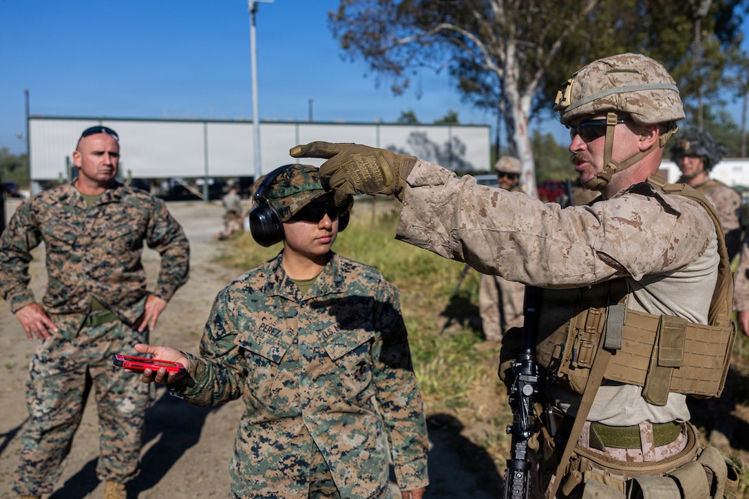 U.S. Marine Corps Cpl. Nicholas Bodily, a light armored vehicle driver, right, with 4th Light Armored Reconnaissance (LAR), 4th Marine Division is briefed by Cpl. Perez Priscilla, center, a range coach, middle and 1st Sgt. Kevin Robinson, company First Sgt, left, both with 4th LAR, during the rifle skill range portion event during the 2026 Bushmaster Competition, Camp Pendleton, California, March 25, 2026. This year, hosted by 4th Light Armored Reconnaissance, 4th Marine Division, the friendly competition gathers Light Armored Vehicle crews from across the U.S. Marine Corps, Australia and New Zealand to test their tactical and technical skills. (U.S. Marine Corps photo by Sgt. Aaron TorresLemus)