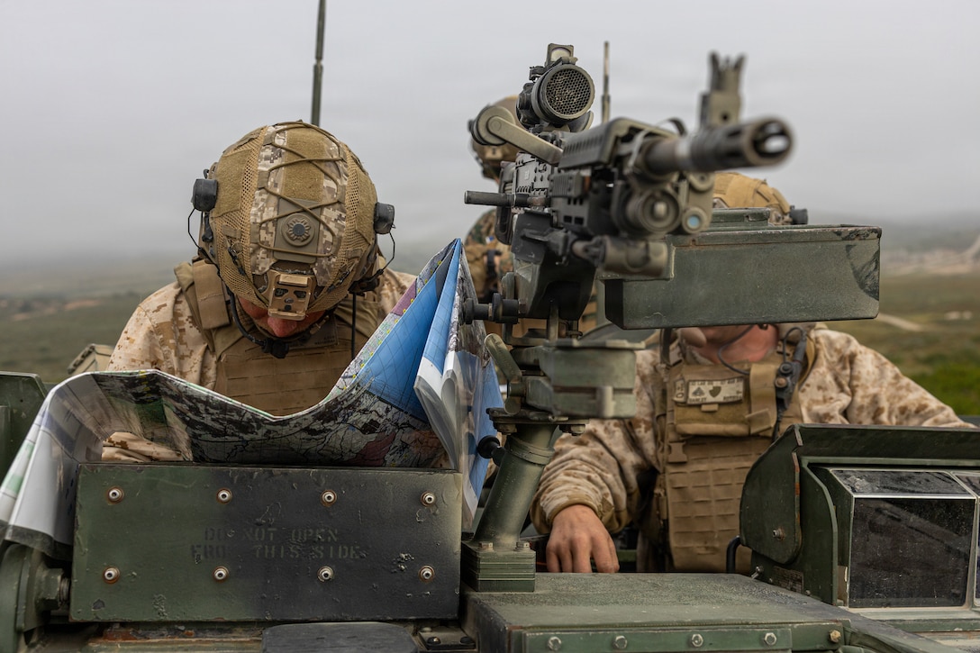 U.S. Marine Corps Sgt. Nathaniel Schneiders, left and Cpl. Ryan Danley, both light armor reconnaissance Marines with 3d Light Armored Reconnaissance, 1st Marine Division, plot grid points for the mounted land navigation event during the 2026 Bushmaster Competition, Camp Pendleton, California, March 26, 2026. This year, hosted by 4th Light Armored Reconnaissance, 4th Marine Division, the friendly competition gathers Light Armored Vehicle crews from across the U.S. Marine Corps, Australia and New Zealand to test their tactical and technical skills. (U.S. Marine Corps photo by Sgt. Aaron TorresLemus)