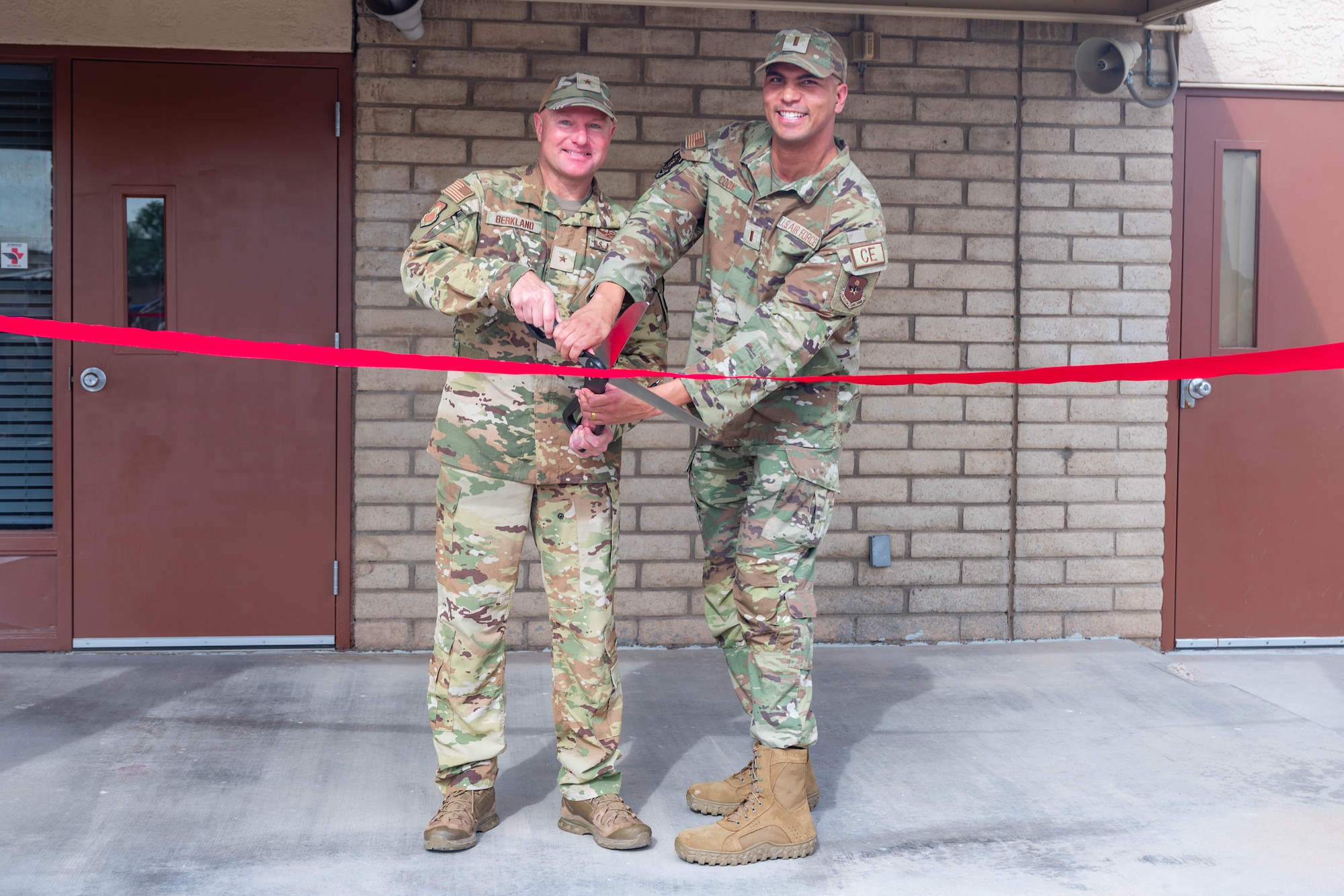 U.S. Air Force Brig. Gen. David Berkland (left), 56th Fighter Wing commander, and 2nd Lt. Nigel Cook (right), 56th Civil Engineer Squadron project programmer, pose for a picture while cutting a ribbon to celebrate the opening of Fire Station 2, March 31, 2026, at Luke Air Force Base, Arizona.