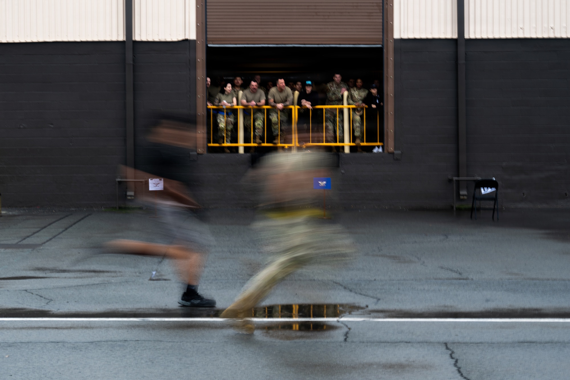 Airmen from the 735th Air Mobility Squadron complete a timed sprint during the mobility Vanguard on Joint Base Pearl Harbor-Hickam, Hawaii, March 13, 2026. One portion of the Vanguard included a combative fitness assessment, evaluating speed, fitness and combat skills. (U.S. Air Force photo by Staff Sgt. Shelby Rapert)