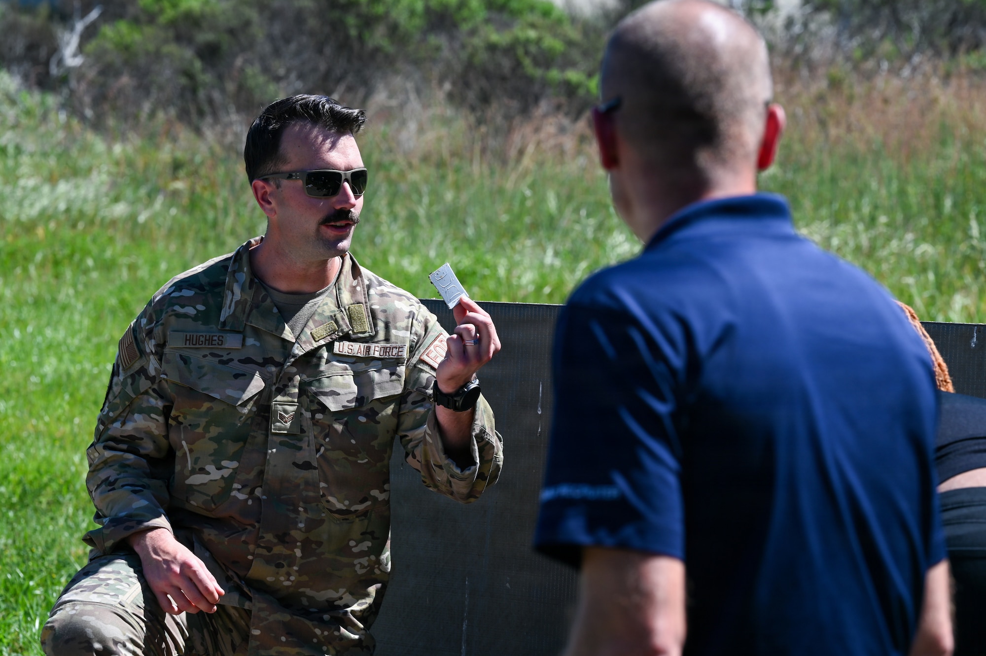 U.S. Air Force Senior Airman Dylan Hughes, 30th Civil Engineer Squadron Explosive Ordnance Disposal technician, shows pieces of an improvised explosive device after a demonstration outside an EOD facility.