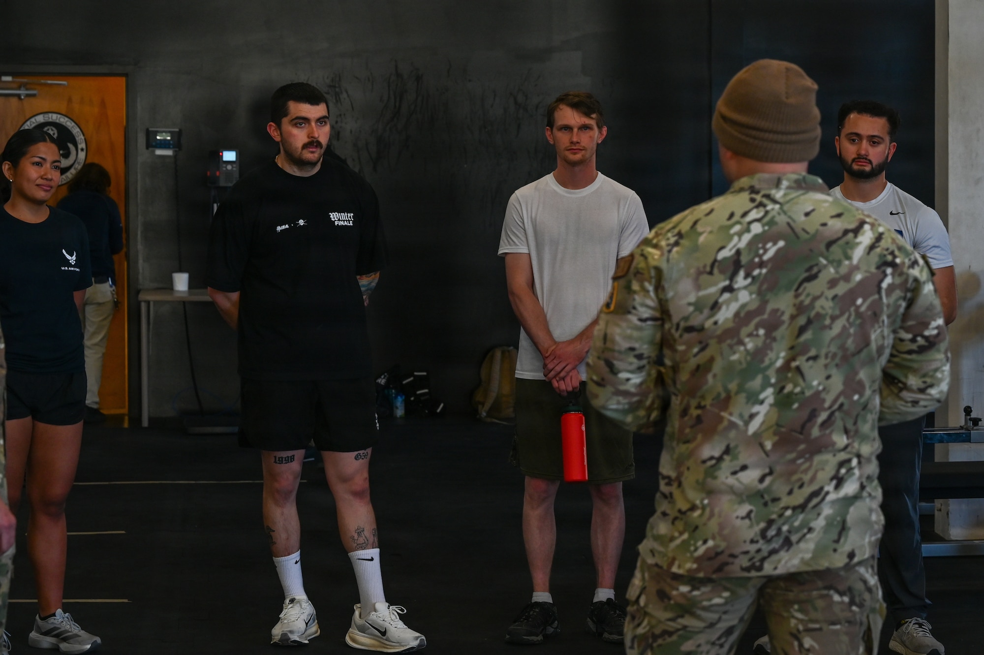 Delayed entry program candidates stand together and listen to a lecture.