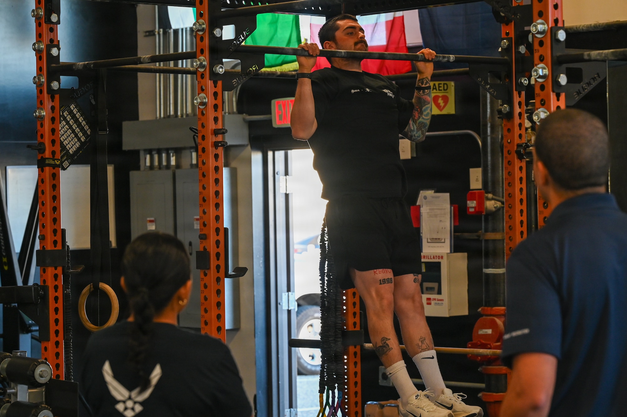 A delayed entry program candidate performs a pull-up at a gym.