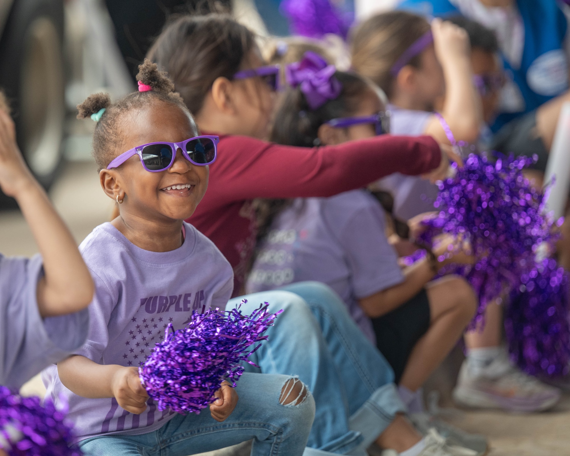 A child holds a pom pom during a celebratory parade to honor the Month of the Military Child at Altus Air Force Base, Oklahoma, April 3, 2026. The Month of the Military Child is dedicated to recognizing the sacrifices and resilience of children in military families. (U.S. Air Force photo by Airman 1st Class Emma Wright)
