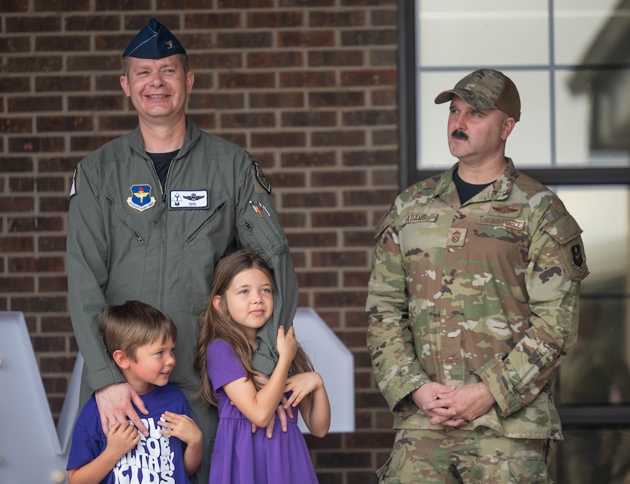 U.S. Air Force Col. Richard Kind, 97th Air Mobility Wing (AWM) commander, left, stands with his kids and Chief Master Sgt. Jonny Adams, 97th AMW command chief, right, during the reading of a proclamation to honor the Month of Military Child at Altus Air Force Base, Oklahoma, April 3, 2026. The Month of the Military Child celebrates the courage and perseverance of children growing up in military families. (U.S. Air Force photo by Airman 1st Class Emma Wright)