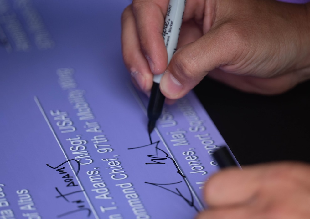 U.S. Air Force Maj. Aaron Jones, 97th Force Support Squadron commander, signs a proclamation to honor the Month of the Military Child at Altus Air Force Base, Oklahoma, April 3, 2026. The Month of the Military Child is observed to show appreciation for the sacrifices made by military children. (U.S. Air Force photo by Airman 1st Class Emma Wright)