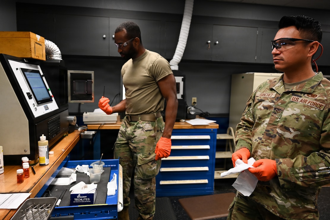 Airmen conduct a routine oil sample test.