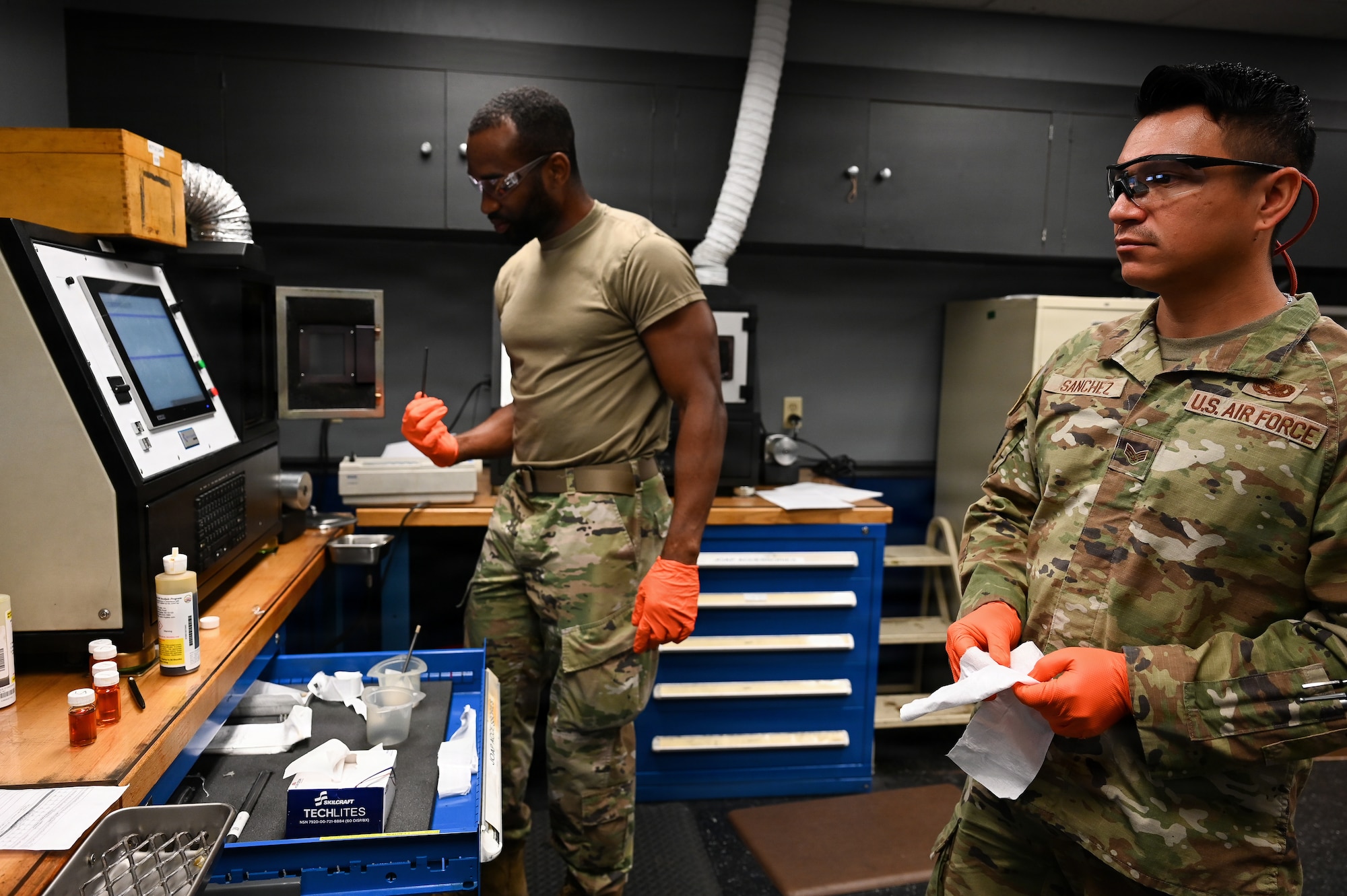 Airmen conduct a routine oil sample test.