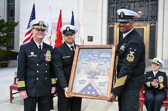 BETHESDA, Md. (Apr. 2, 2026) Command Master Chief Aaron Paul, center, and Master Chief Hospital Corpsman Chevas Watts, senior enlisted leader, Directorate for Surgery, right, Navy Medicine Readiness and Training Command (NMRTC) Bethesda present Capt. Jeffrey Klinger, outgoing commanding officer, NMRTC Bethesda with a gift during a combined change of command and retirement ceremony, at Walter Reed National Military Medical Center, Apr. 2, 2026. NMRTC Bethesda’s mission is to maximize warfighter performance through optimized medical readiness tailored to operational requirements; enhance the readiness of the medical force to sustain expeditionary medical capability; and train and develop the Navy Medicine Force. (U.S. Navy photo Mass Communication Specialist Second Class Alec Kramer)