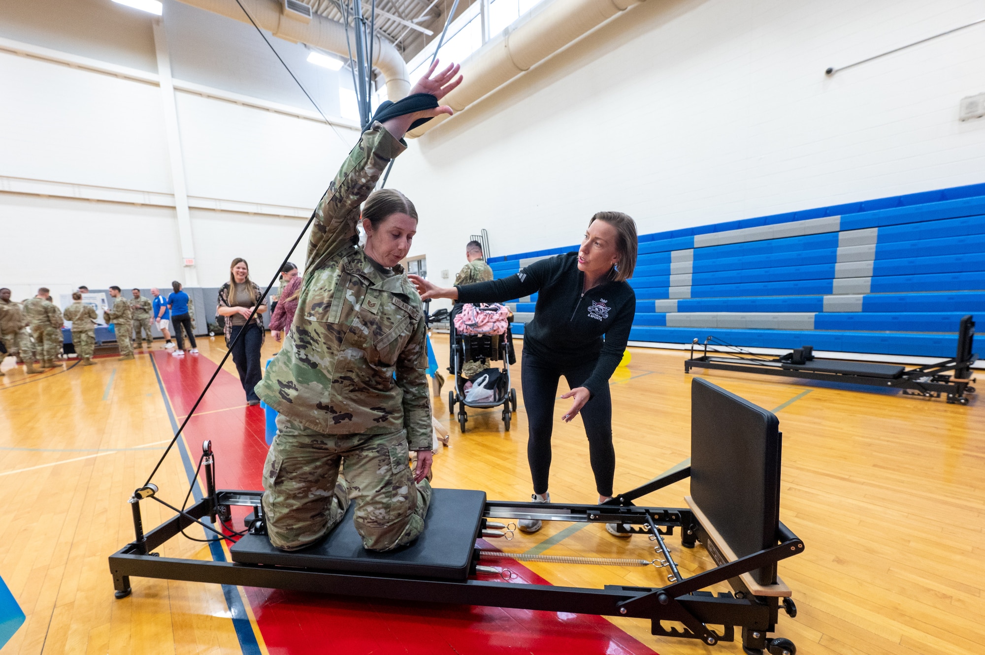 Ali Bednarik, right, 436th Force Support Squadron fitness center program manager, shows U.S. Air Force Tech. Sgt. Heather Schramek, 436th Airlift Wing command chief executive, on how to use a reformer Pilates machine during the 2026 Resilience Team Showcase at Dover Air Force Base, Delaware, March 26, 2026. Physical fitness is one of the pillars of comprehensive Airman fitness along with mental, social and spiritual health. (U.S. Air Force photo by Mauricio Campino)