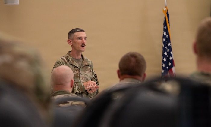 A military member speaks to a crowd