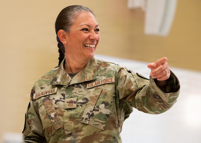 A woman points as she smiles in a photo
