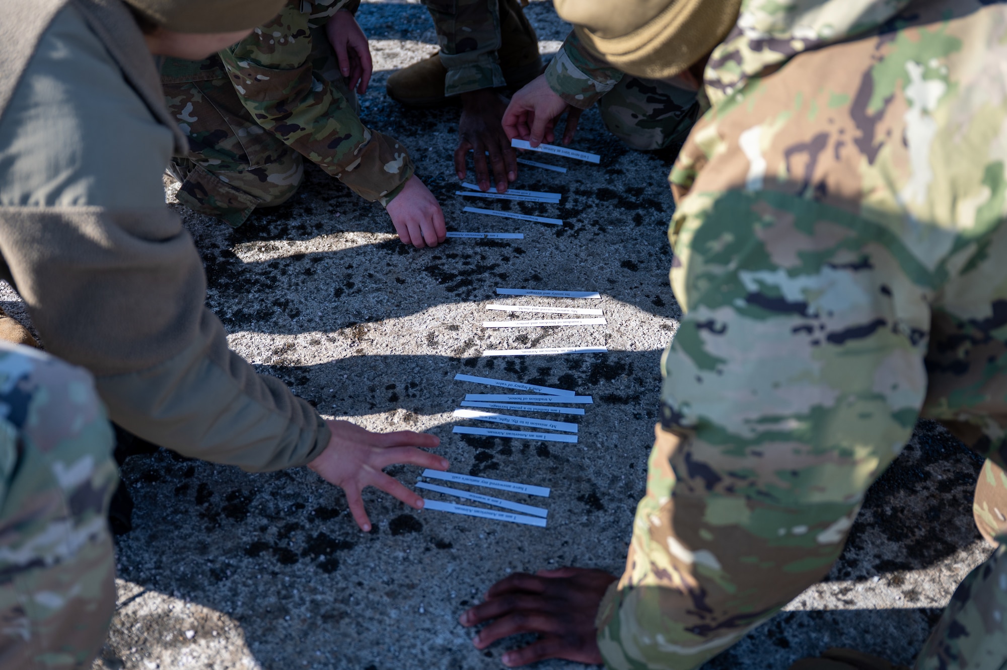 Airman Leadership School students collaborate on a mental task during the Commandant’s Functional Expeditionary Challenge at the Elmendorf Professional Military Education Center on Joint Base Elmendorf-Richardson, Alaska, March 30, 2026. By pairing high-intensity functional movements with immediate academic testing, the challenge simulates the mental fog of combat to ensure leaders can recall critical regulations and course material under physical stress. (U.S. Air Force photo by Airman 1st Class Theodore Gowdy)