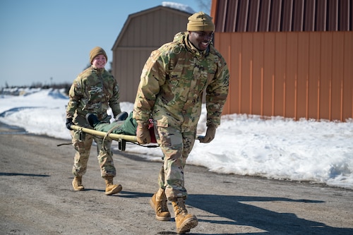 U.S. Air Force Senior Airmen Cajae Nicholas and Alicia Hale, Airman Leadership School students, carry a dummy on a stretcher during the Commandant’s Functional Expeditionary Challenge at the Elmendorf Professional Military Education Center on Joint Base Elmendorf-Richardson, Alaska, March 30, 2026. This specific iteration of the challenge, developed locally at the Elmendorf PME Center, is being evaluated by the Barnes Center for potential Air Force-wide implementation. (U.S. Air Force photo by Airman 1st Class Theodore Gowdy)