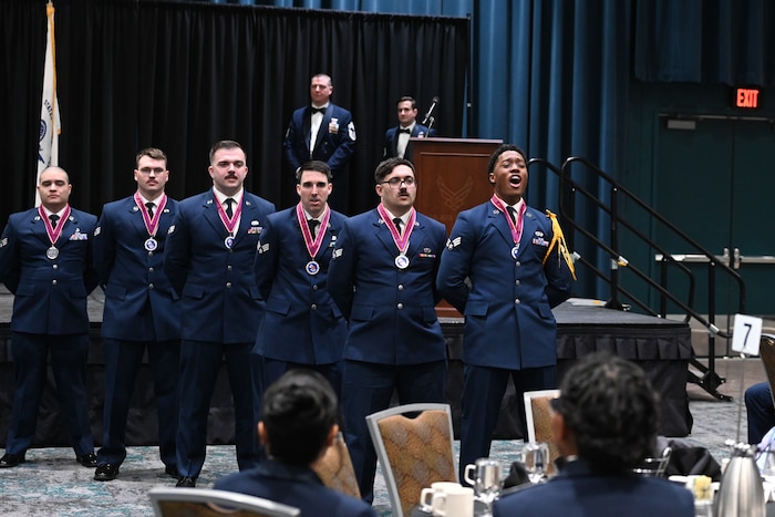 Graduates of the Airman Leadership School stand in formation as their flight leader calls out their flight chant during an ALS gradution ceremony at the William A Egan Civic and Covention Center in Anchorage, Alaska, March 31, 2026. By completing this professional military education milestone, the graduates are now equipped with the foundational leadership skills necessary to drive mission success and maintain readiness across the Air Base Wing and beyond. (U.S. Air Force photo by Airman 1st Class Theodore Gowdy)