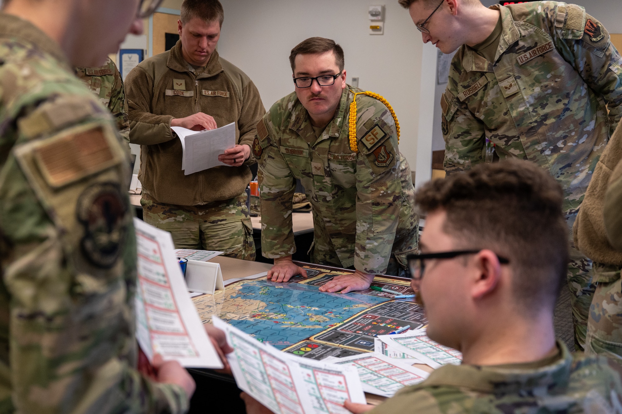 Airman Leadership School students work together on a strategic exercise at the Elmendorf Professional Military Education Center on Joint Base Elmendorf-Richardson, Alaska, March 27, 2026. This feature of professional military education provides a low-risk, high-impact environment for students to practice leveraging diverse career-field knowledge to solve multi-faceted mission challenges. (U.S. Air Force photo by Airman 1st Class Theodore Gowdy)
