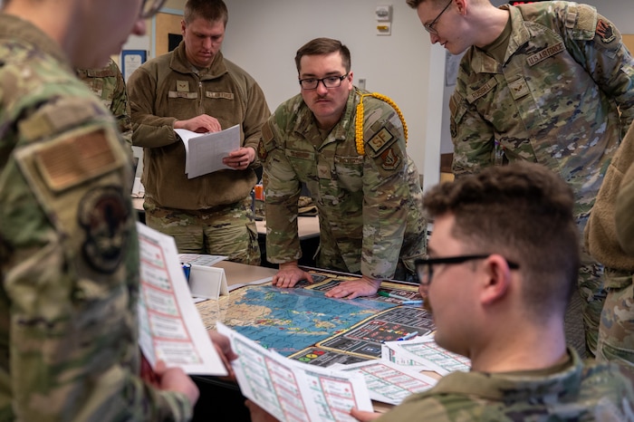 Airman Leadership School students work together on a strategic exercise at the Elmendorf Professional Military Education Center on Joint Base Elmendorf-Richardson, Alaska, March 27, 2026. This feature of professional military education provides a low-risk, high-impact environment for students to practice leveraging diverse career-field knowledge to solve multi-faceted mission challenges. (U.S. Air Force photo by Airman 1st Class Theodore Gowdy)