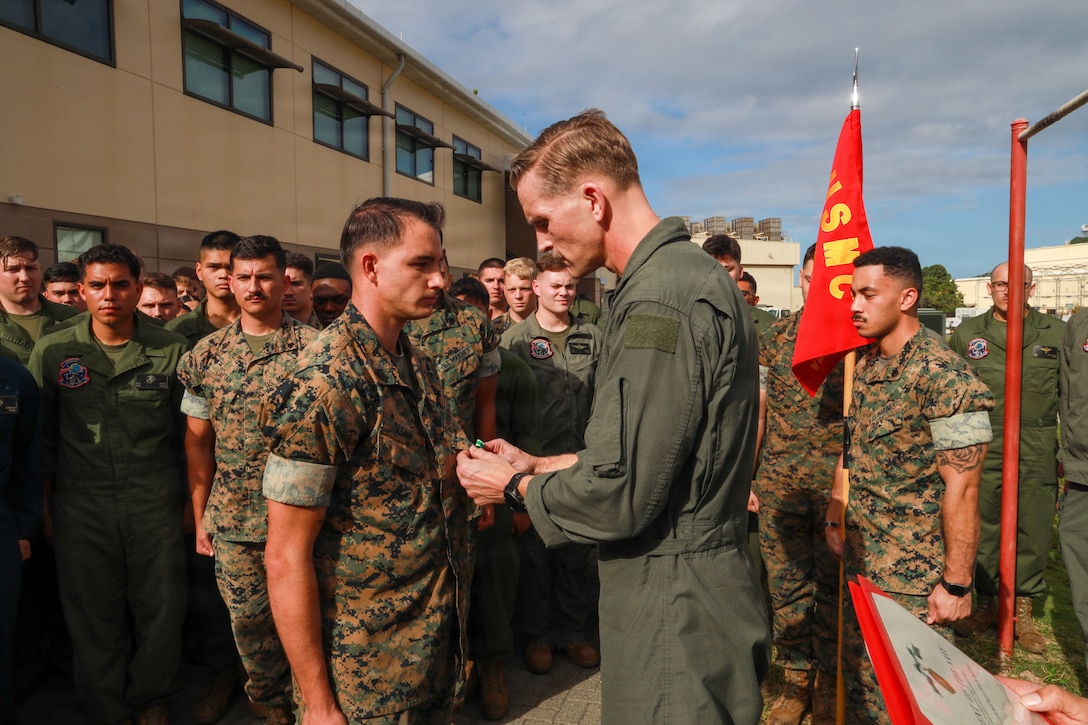 U.S. Marine Corps Lt. Col. Paul Cordes, commanding officer of Marine Aerial Refueler Transport Squadron (VMGR) 153, Marine Aircraft Group 24, 1st Marine Aircraft Wing, awards Sgt. Garrett Sloan, a loadmaster with VMGR-153, the Navy and Marine Corps Commendation Medal at Marine Corps Air Station Kaneohe Bay, Hawaii, March 5, 2026. Sloan received the award after rescuing two local children who were swept out to sea by a rip current while swimming at Makapu’u beach. (U.S. Marine Corps photo by Lance Cpl. Chandler Evans)
