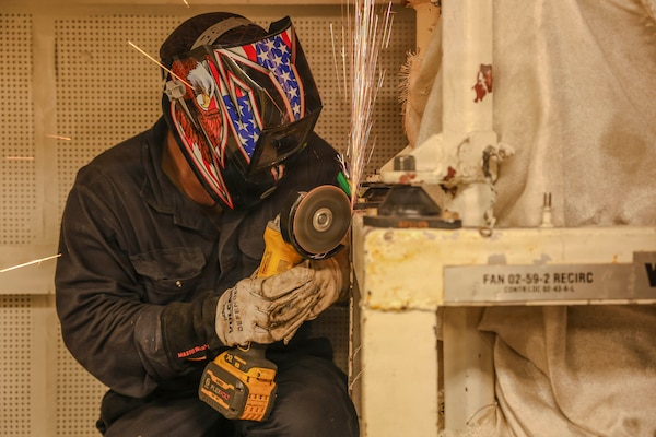Hull Maintenance Technician 2nd Class Christian Deang, assigned to Southwest Regional Maintenance Center, grinds a fan unit bracket aboard Whidbey Island-class dock landing ship USS Ashland (LSD 48) as part of ship wartime repair and maintenance exercise (SWARMEX) in Cebu, Philippines, March 25, 2026.