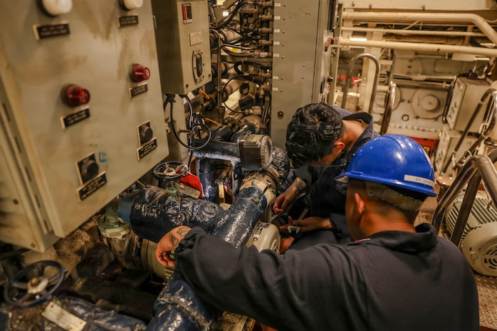 Engineman 2nd Class Walid Ventayen, left, and Engineman 1st Class Michael Carantes, assigned to Southwest Regional Maintenance Center, replace an engine component in the main engine room while Whidbey Island-class dock landing ship USS Ashland (LSD 48) is in port in Cebu, Philippines, as part of ship wartime repair and maintenance exercise (SWARMEX), March 25, 2026.