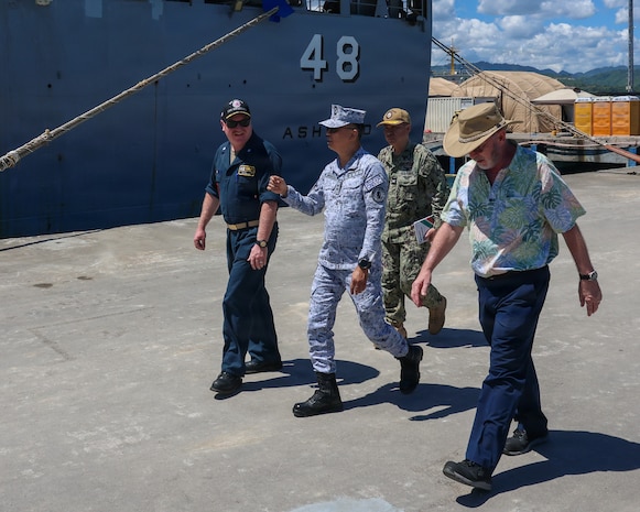 Cmdr. Adam Peeples, commanding officer of Whidbey Island-class dock landing ship USS Ashland (LSD 48) [left], walks with Philippine Navy Rear Adm. Juario C. Marayag, Commander, Naval Sea Systems Command [center], during a visit as part of ship wartime repair and maintenance exercise (SWARMEX) in Cebu, Philippines, March 25, 2026.