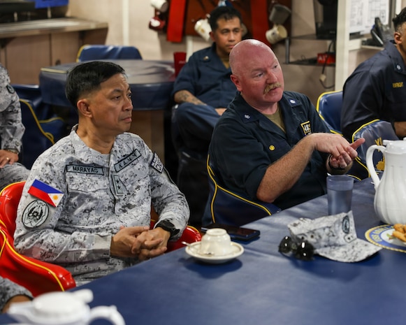 Cmdr. Adam Peeples, commanding officer of Whidbey Island-class dock landing ship USS Ashland (LSD 48) [right], speaks to Philippine Navy Rear Adm. Juario C. Marayag, Commander, Naval Sea Systems Command, about ship wartime repair and maintenance exercise (SWARMEX) during a visit to the ship in Cebu, Philippines, March 25, 2026.