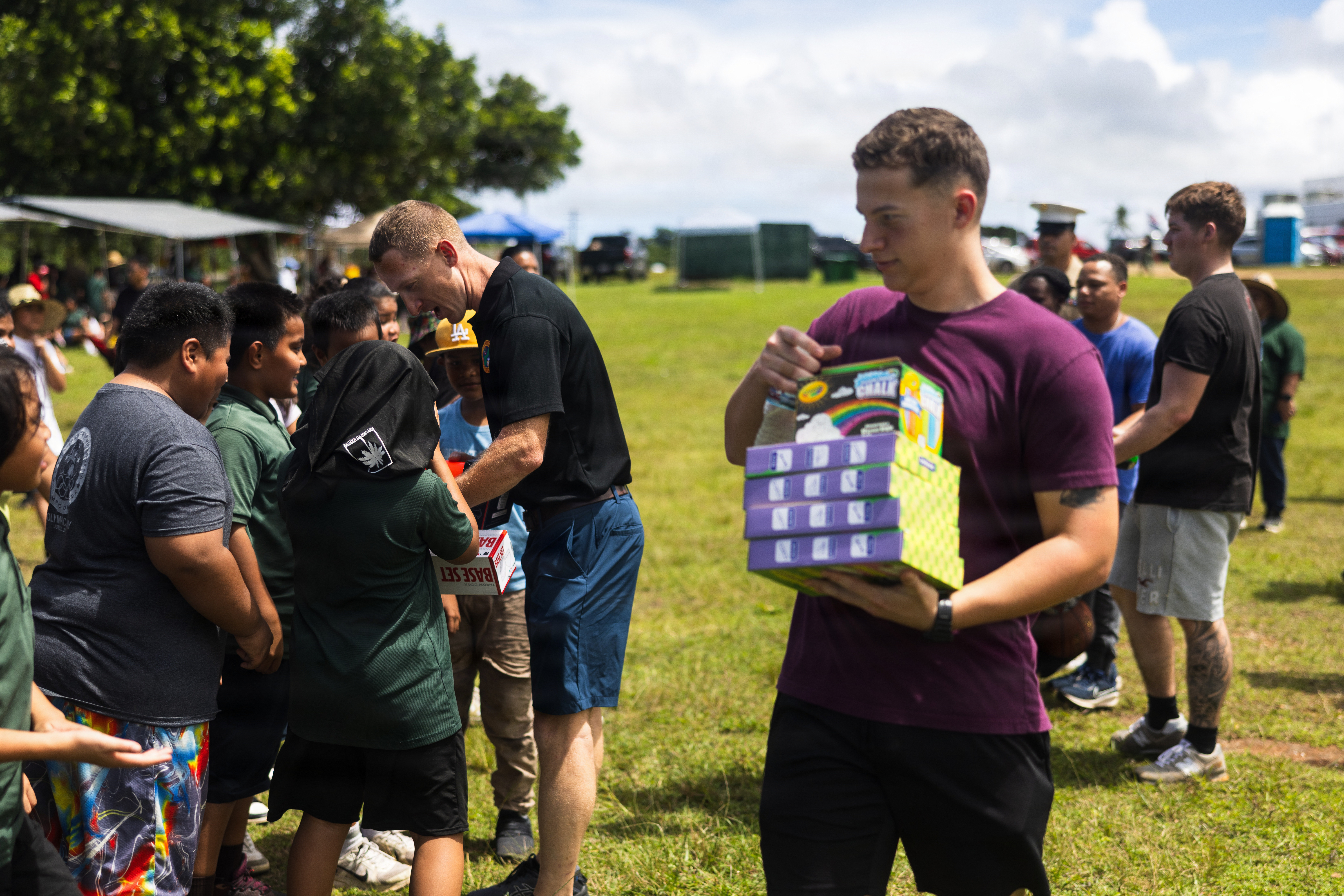 U.S. Marine Corps Maj. Michael Guard, company commander, Headquarters Company, Marine Corps Base Camp Blaz, and Pfc. Jadon Samulski,  military police, Provost Marshal's Office, MCB Camp Blaz, hand out toys during Finegayan Elementary School's 1st Annual Mes CHamoru Field Day at Dededo, Guam, March 27, 2026. Marines from Camp Blaz donated sports equipment and joined field day activities, embracing CHamoru culture and reinforcing ties with Guam residents. (U.S. Marine Corps photo by Sgt. Brayden Daniel)
