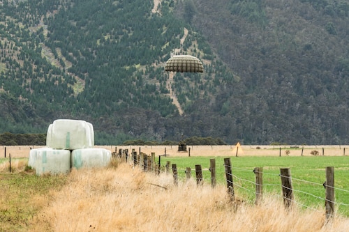A cargo bundle descending into a field during airdrops