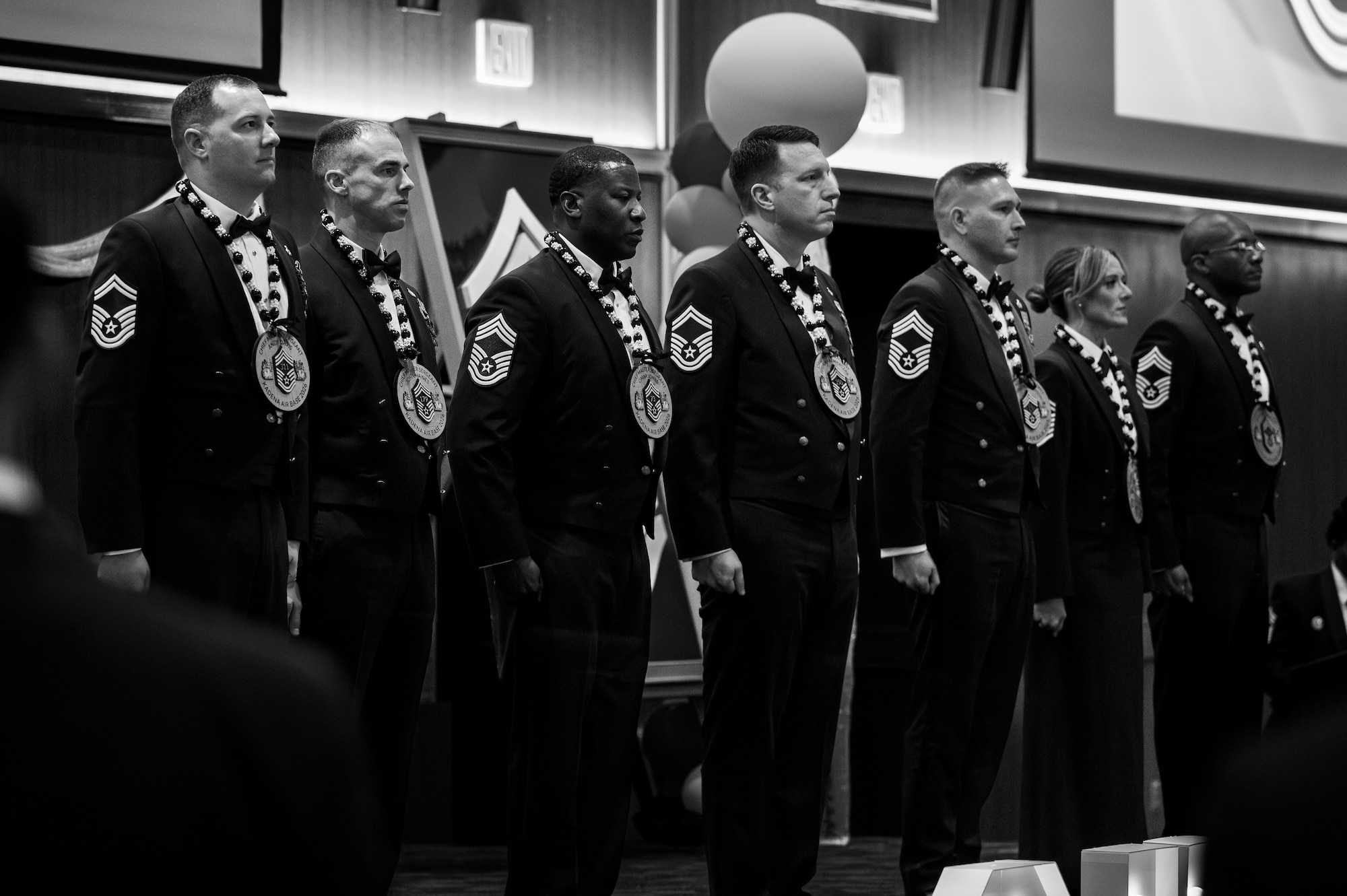 U.S. Air Force newly inducted chief master sergeants stand at attention as they get recognized during a chief induction ceremony at Kadena Air Base, Japan, March 28, 2026. The seven new chiefs were formally inducted marking their transition into the highest enlisted tier. (U.S. Air Force photo by Airman 1st Class Francisco Huerta)