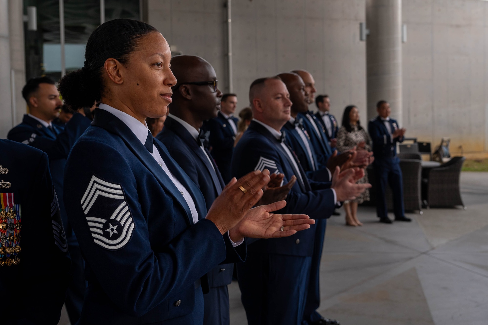 U.S. Air Force Chief Master Sgt. Lynnette Banks, 18th Wing Staff Agency senior enlisted leader, claps for inductees during a chief induction ceremony at Kadena Air Base, Japan, March 28, 2026. Chief master sergeant is the highest enlisted rank, reserved for Airmen who demonstrate exceptional leadership and commitment. (U.S. Air Force photo by Airman 1st Class Nathaniel Jackson)