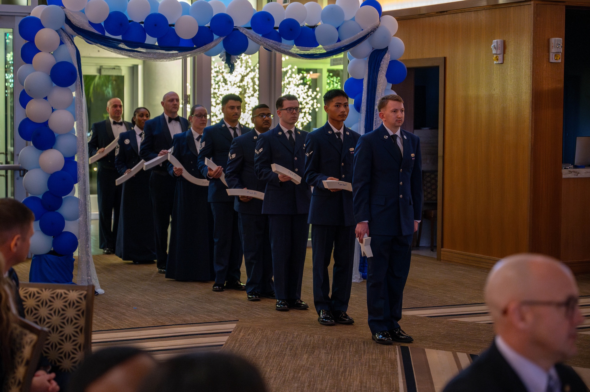 U.S. Air Force Airmen assigned to the 18th Wing stand with deconstructed pieces of the chief master sergeant enlisted rank as part of the stripe ceremony during a chief induction ceremony at Kadena Air Base, Japan, March 28, 2026. The stripe ceremony is used to signify all the ranks the inductees surpassed on their path to their new rank. (U.S. Air Force photo by Airman 1st Class Nathaniel Jackson)